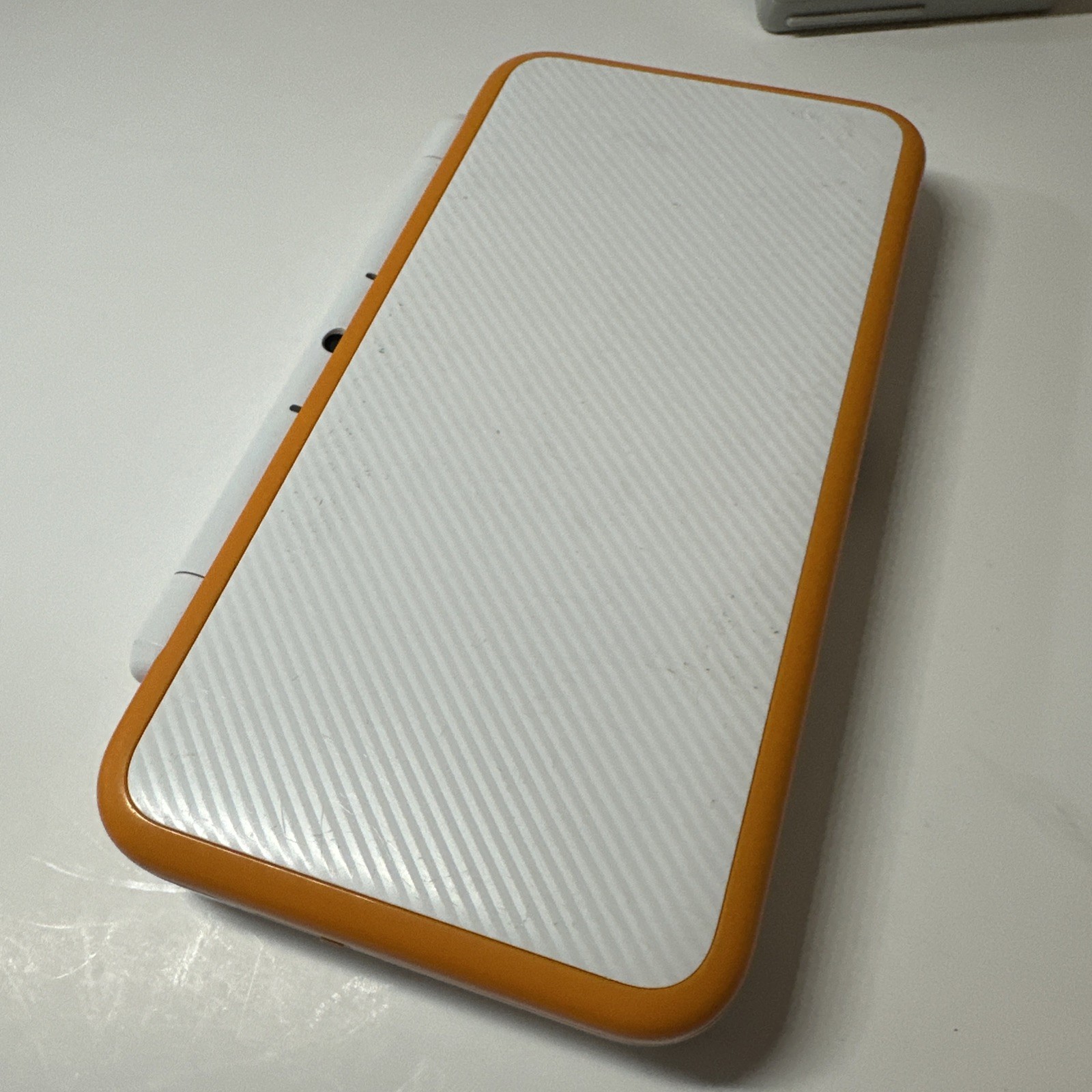Nintendo 2DS XL – Orange & White Bundle (Top Screen Crack/ Non-OEM Charger)