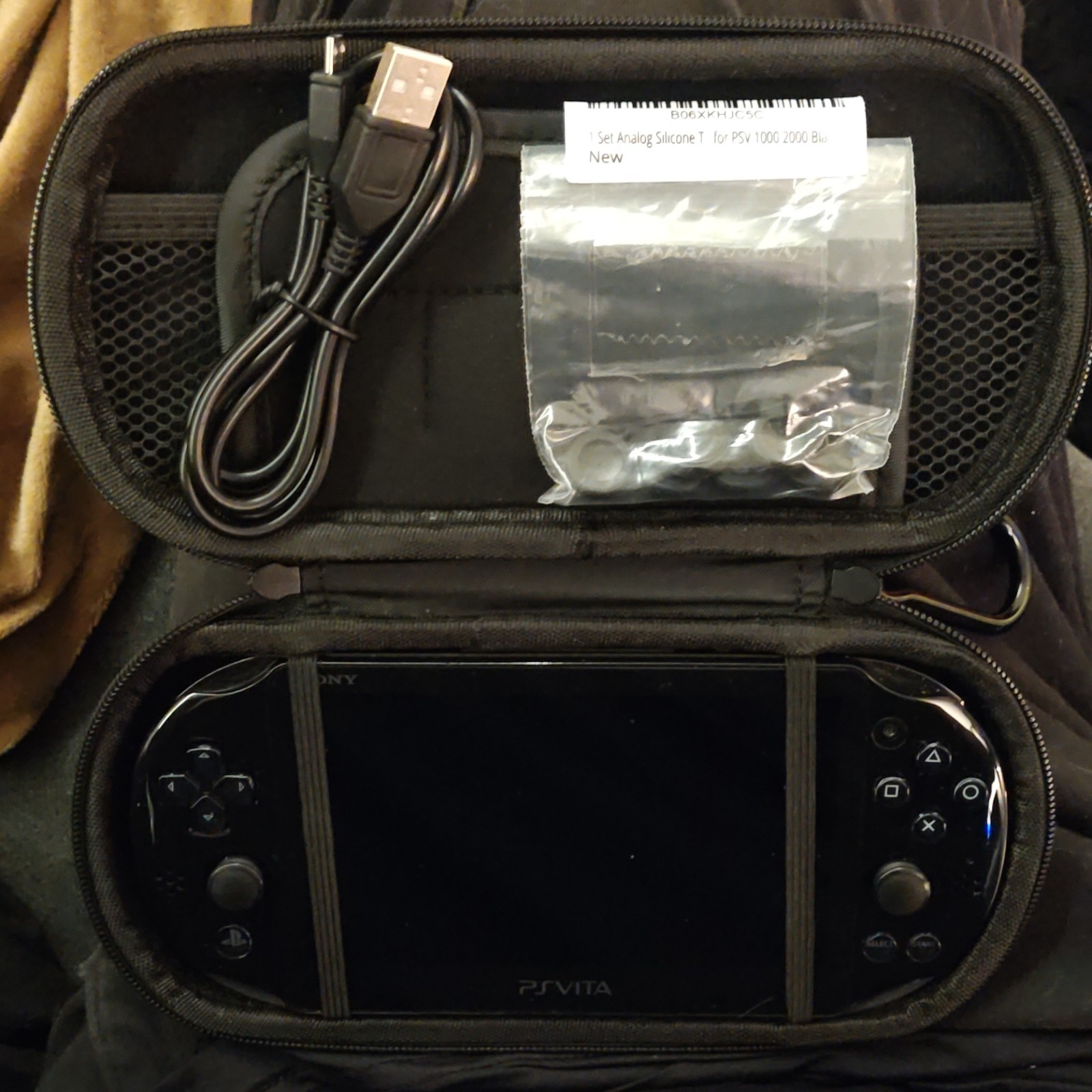 Sony PS Vita with games, Carrying Case, charge cable, and Thumb Grips.
