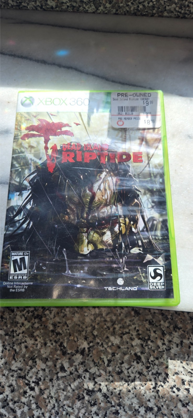 pre-owned copy of the video game Dead Island: Riptide for the Xbox 360 platform