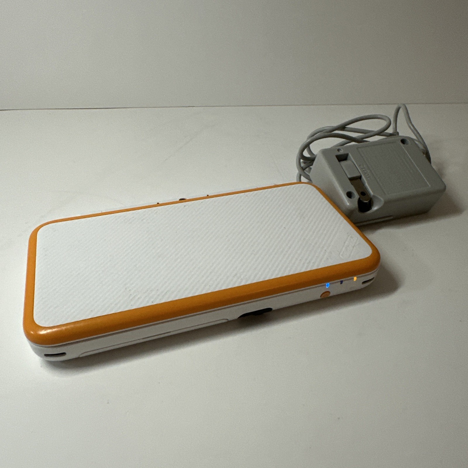 Nintendo 2DS XL – Orange & White Bundle (Top Screen Crack/ Non-OEM Charger)