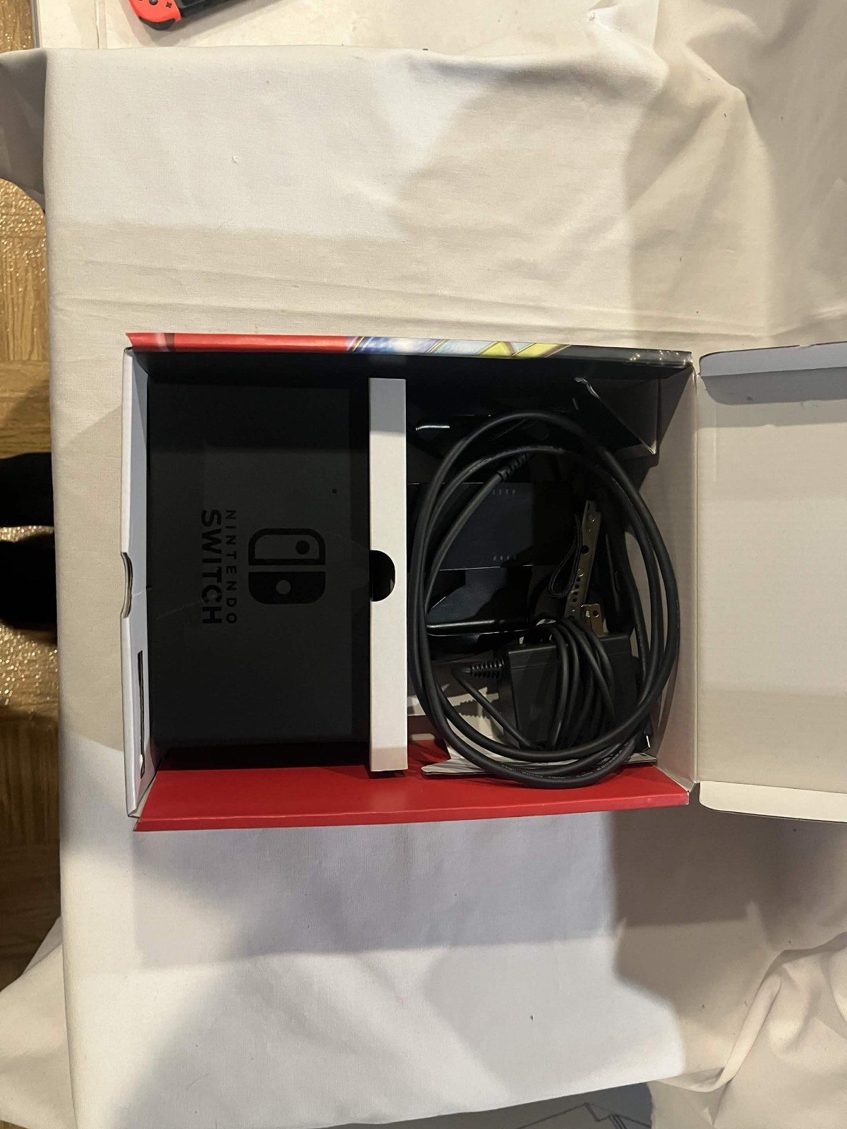 Nintendo Switch with accessories and box with red and blue joy cons