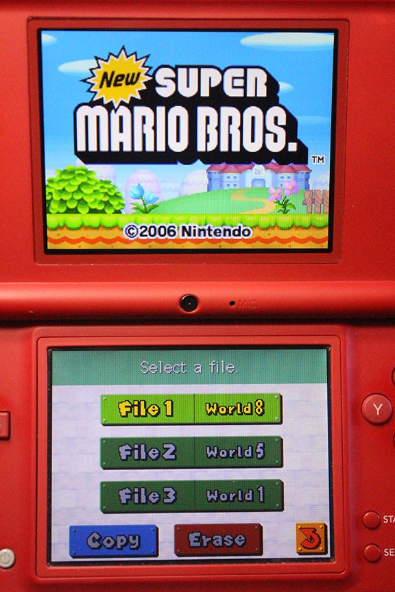 Nintendo DSi Red Handheld Game Console w/ Mario Skin Cover + Super Mario DS Game