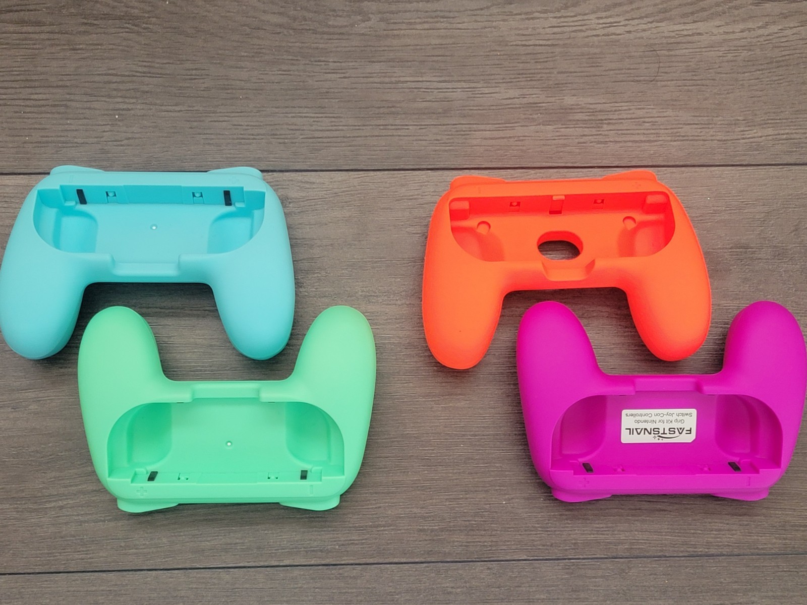 Four NINTENDO Switch Controller Grips. Red, Purple, Light Blue, Light Green.